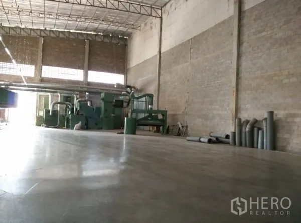 Factory for rent or sale in Krathum Baen, Samut Sakhon - Spacious factory interior with polished concrete floor, high steel roof and industrial machines ready for production.