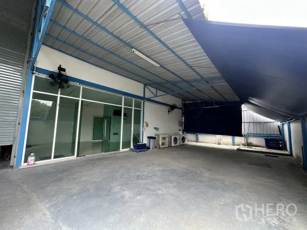工厂 出租或出售在Bang Yai, Nonthaburi - 带顶装卸区，玻璃办公室外立面与室外空调机组。