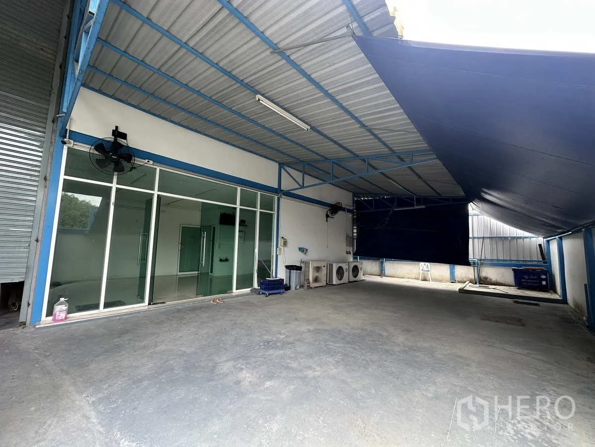 工厂 出租或出售在Bang Yai, Nonthaburi - 带顶装卸区，玻璃办公室外立面与室外空调机组。