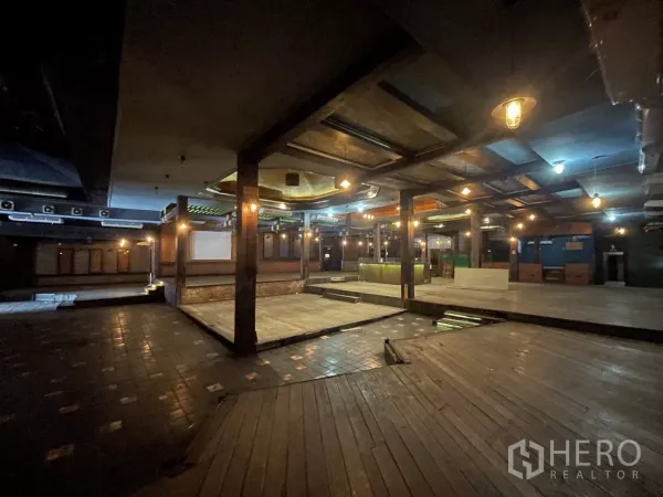 零售空间 出租在Suan Luang, Bangkok - 大型室内大厅，木地板、中心平台和暖色吊灯。