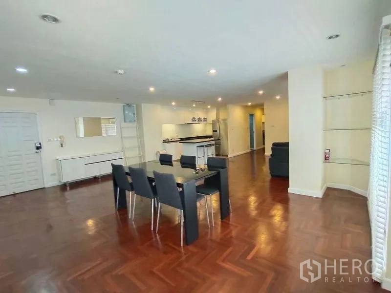 Condominium for rent or sale in Bang Rak, Bangkok - Bright dining area with six‑seat table beside the open kitchen and built‑in corner shelves.