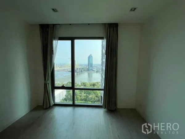 Condominium for sale - Spacious room with full-height window showcasing river and skyline vistas.