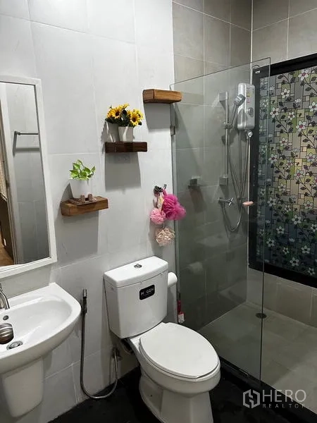 独立式住宅 出租在Prawet, Bangkok - 卫浴间，玻璃淋浴房、坐便与置物架。