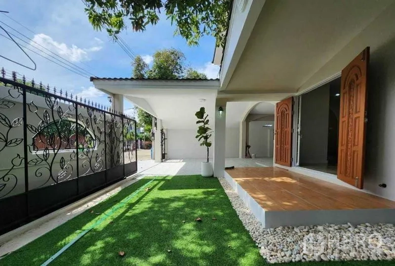 บ้าน ให้เช่าในLam Luk Ka, Pathum Thani - ลานข้างบ้านปูหญ้าเทียม พร้อมชานพักและรั้วเหล็กดัดลายใบไม้