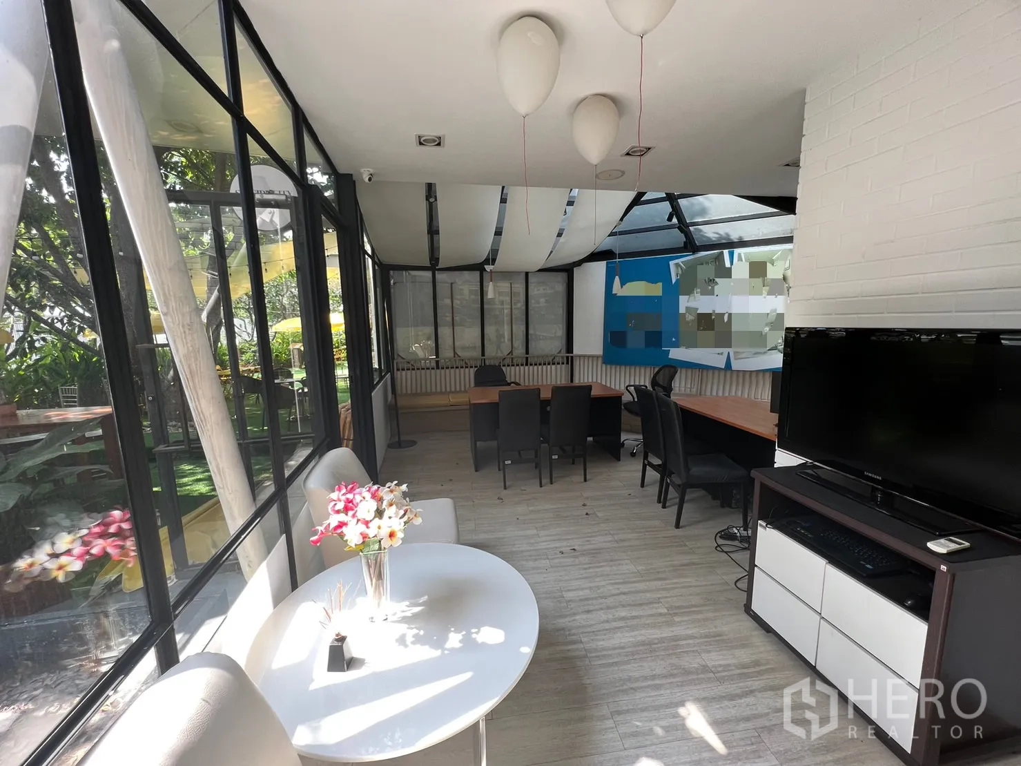 零售空间 出租在Pathum Wan, Bangkok - 室内采光充足，落地窗、小圆桌与长工作台，可眺望绿化。