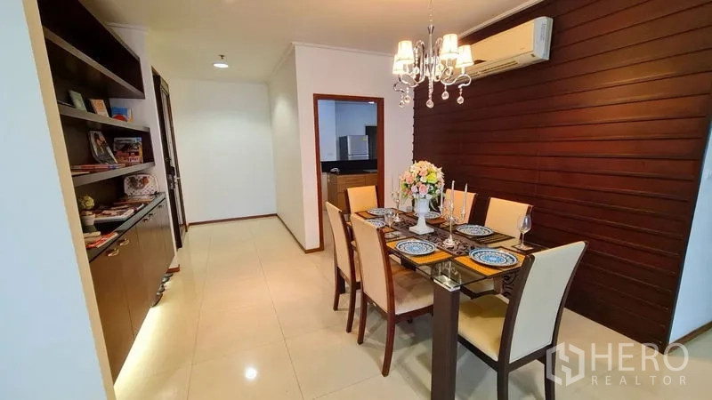 อพาร์ทเมนท์ ให้เช่าในWatthana, Bangkok - มุมรับประทานอาหารโต๊ะกระจก 6 ที่นั่ง ใต้โคมแชนเดอเลียร์ ผนังไม้และชั้นบิวท์อิน