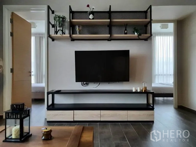 Condominium for rent or sale in Watthana, Bangkok - TV console with floating shelves between two bedroom doors in the living room.