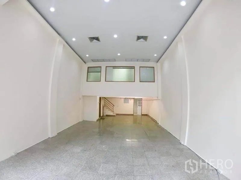 Office Space for rent in Khlong Toei, Bangkok - Spacious high-ceiling office hall with mezzanine level and spot lighting.