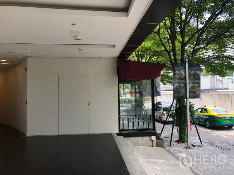 零售空间 出租在Watthana, Bangkok - 带坡道的有顶入口与玻璃店面，临街绿树成荫。
