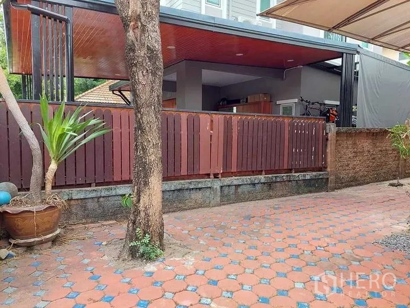 Detached House for sale in Bueng Kum, Bangkok - Paved front yard with a mature tree, wooden fence and covered terrace.