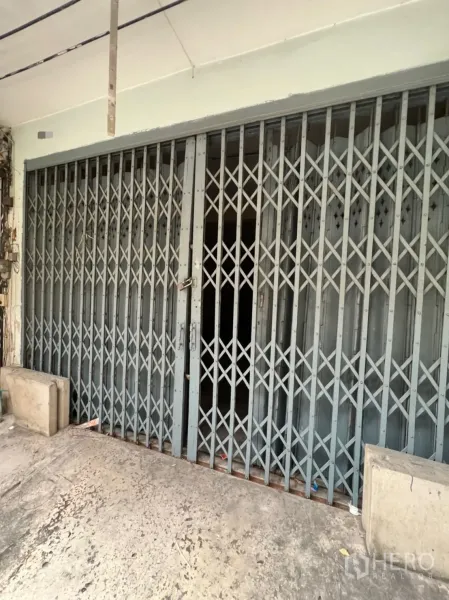 店屋 出租在Watthana, Bangkok - 店屋门面钢制折叠闸门特写，带人行道前坪。