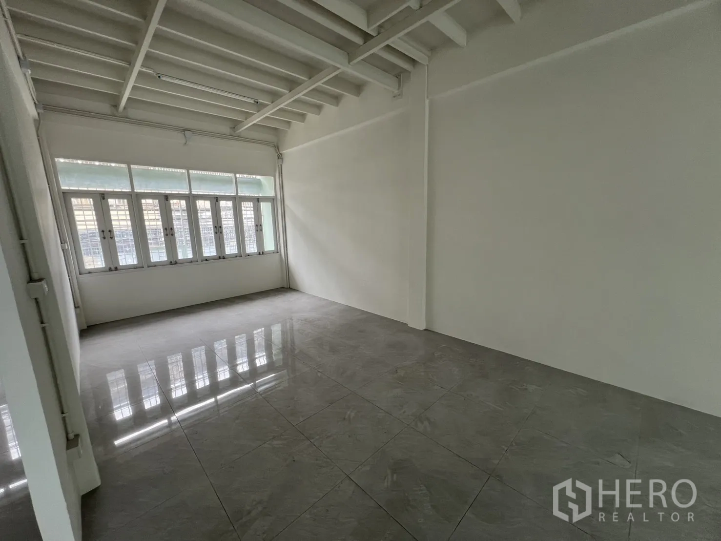 店屋 出租在Khlong Toei, Bangkok - 明亮瓷砖办公间，整面窗与梁架天花。