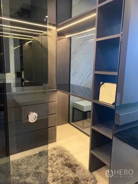 Condominium for sale in Pathum Wan, Bangkok - Walk-in closet with glass door, open shelving and soft LED lighting.