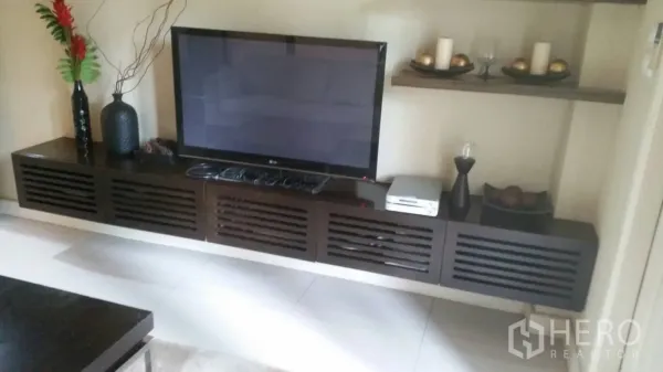 บ้าน ให้เช่าในLat Krabang, Bangkok - ผนังทีวีในห้องนั่งเล่นพร้อมชั้นวางของและตู้คอนโซลไม้สีเข้ม