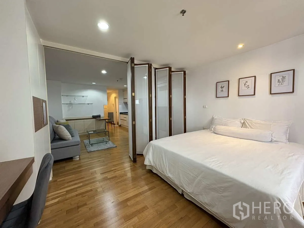 公寓 出租在Khlong Toei, Bangkok - 从卧室看向客厅，折叠门与通铺木地板。