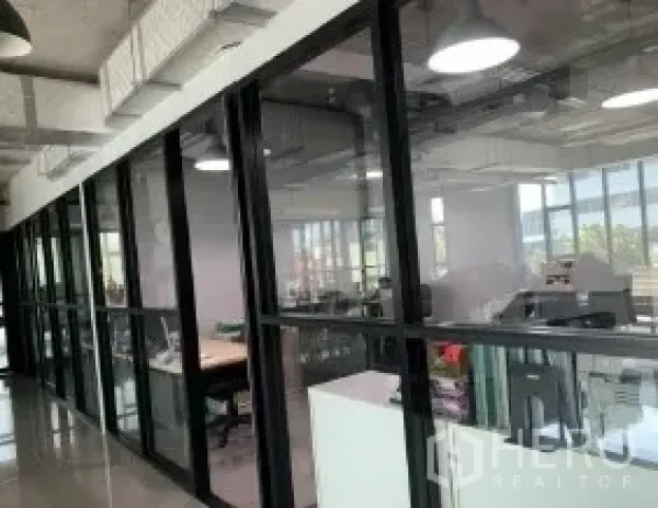 办公空间 出租在Phaya Thai, Bangkok - 落地玻璃墙后的开放式办公区，可见城市景观。