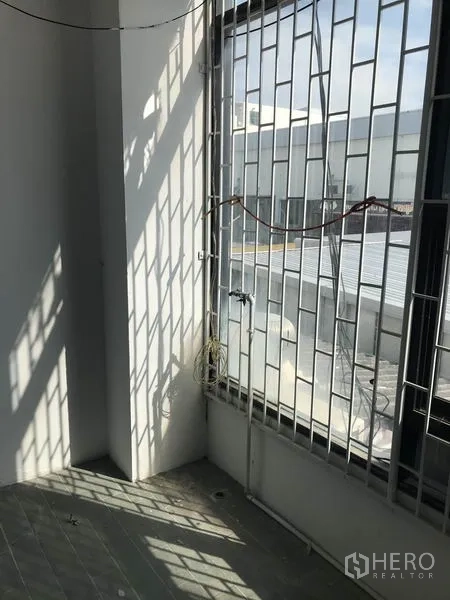 办公空间 出租在Khlong Toei, Bangkok - 采光充足的角落，带安全护栏的高窗，可见周边建筑。