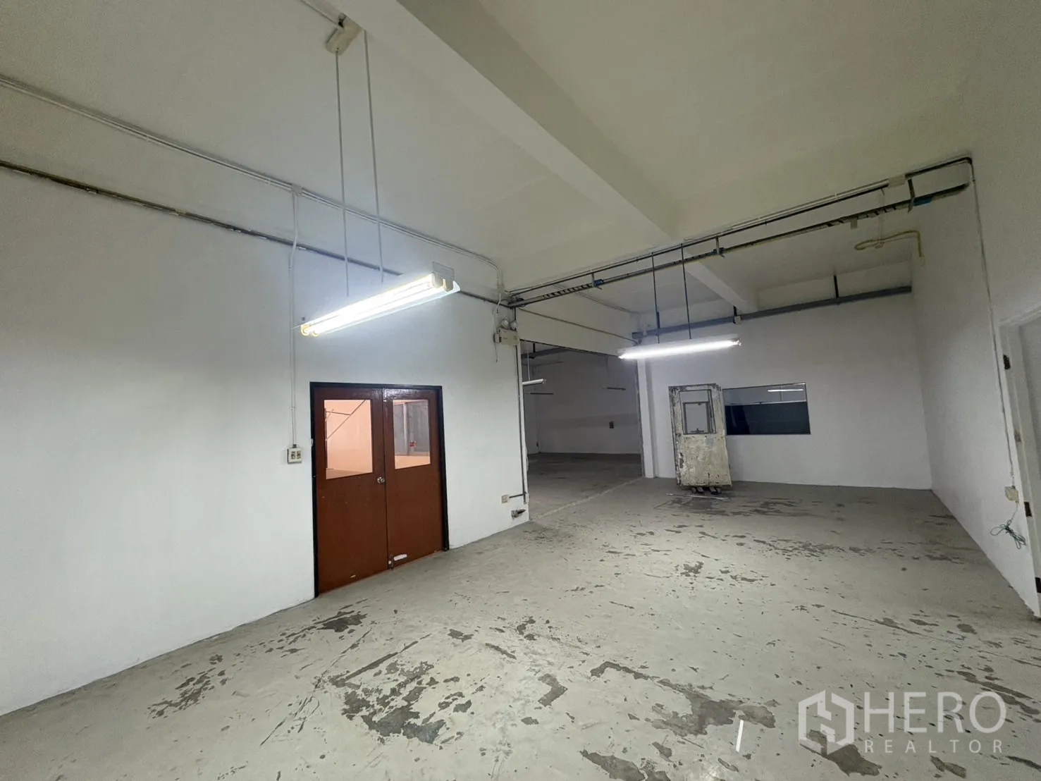 คลังสินค้า ให้เช่าในBang Phli, Samut Prakan - โซนโกดังพร้อมประตูคู่และแนวท่อสาธารณูปโภคตามผนัง