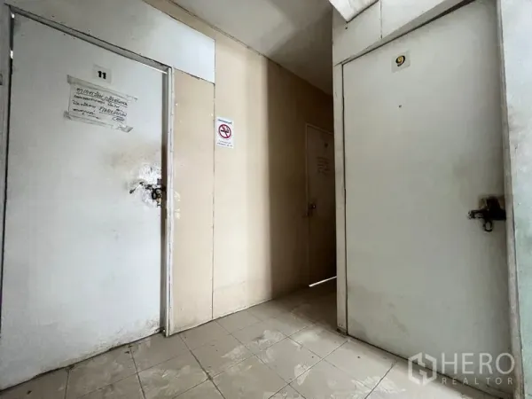 店屋 出租在Watthana, Bangkok - 室内走廊铺瓷砖，带编号可上锁的多扇门，适合作为储物或小房间。