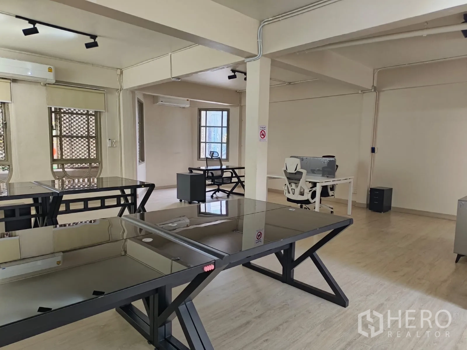 ตึกแถว for rent in Watthana, Bangkok - พื้นที่ทำงานกว้างพร้อมโต๊ะกระจกสีดำและท่อเดินลอย.