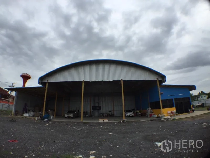 Warehouse for rent in Mueang Pathum Thani, Pathum Thani - Wide loading bay with tall columns under a curved metal roof at the warehouse.