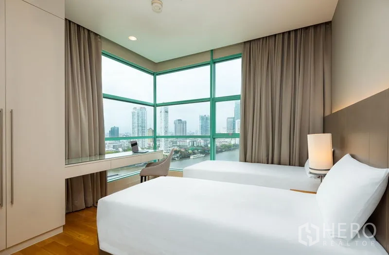 Condominium for rent in Bang Kho Laem, Bangkok - Corner room with twin beds and wraparound windows facing the Chao Phraya River.