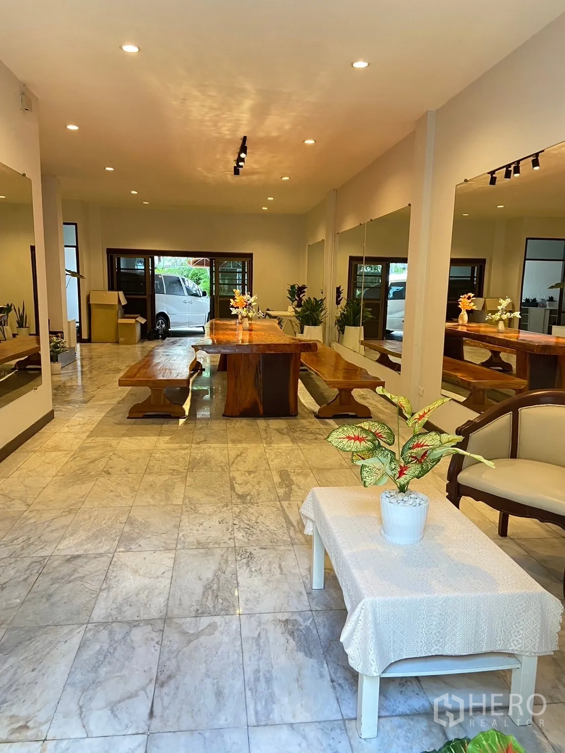 Home Office for rent in Watthana, Bangkok - Open-plan hall with long wooden table, mirror walls and access toward the front entry.
