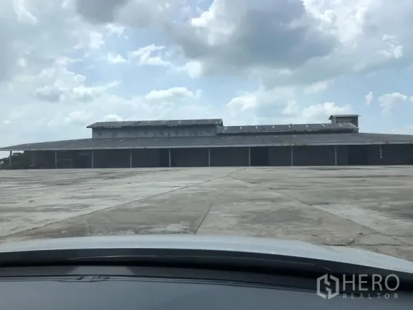 คลังสินค้า ให้เช่าในChaloem Phra Kiat, Saraburi - โกดังโครงเหล็กในสระบุรี ประตูม้วนหลายช่องและลานคอนกรีตกว้าง ใต้ท้องฟ้ามีเมฆ