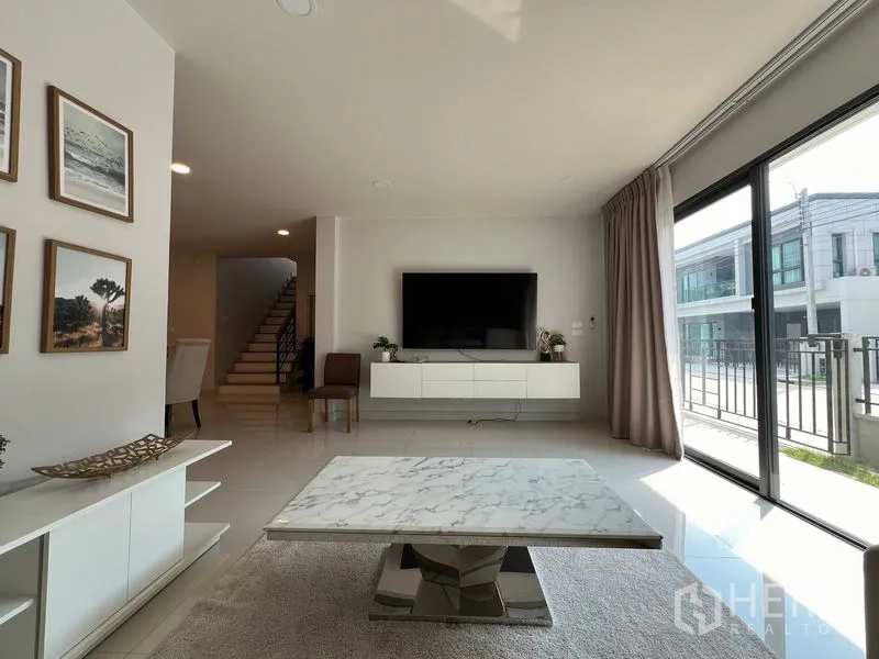 Detached House for rent in Bang Phli, Samut Prakan - Living room TV wall with sliding glass doors and marble coffee table.