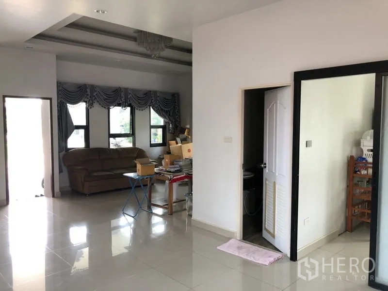 บ้าน ขายในLam Luk Ka, Pathum Thani - มุมนั่งเล่นมีโซฟา หน้าต่าง และประตูเชื่อมห้องน้ำ