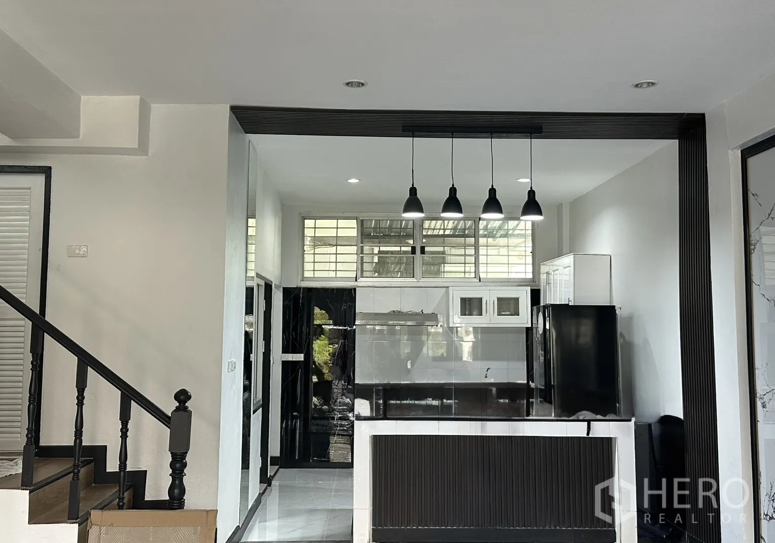 ทาวน์เฮาส์ for rent in Watthana, Bangkok - ครัวโทนขาวดำ เคาน์เตอร์ไอแลนด์ ไฟห้อย และช่องหน้าต่างบน