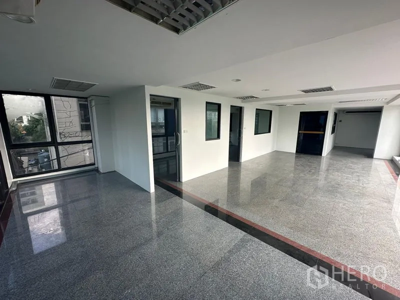 Office Space for rent in Sathon, Bangkok - Spacious office area with internal glass doors, recessed lighting and durable stone floors.