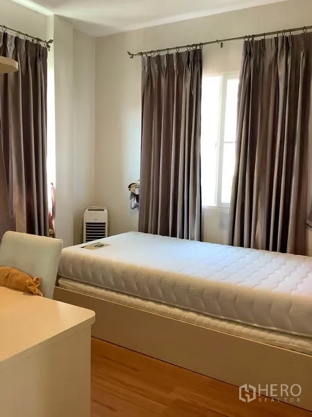 Detached House for rent in Bang Kapi, Bangkok - Secondary bedroom with single bed, study desk and blackout curtains.