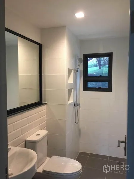 Detached House for sale in Pak Kret, Nonthaburi - Bright bathroom with white wall tiles, shower, toilet and vanity mirror