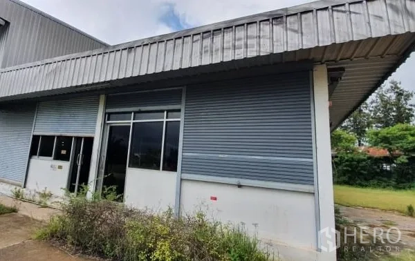 คลังสินค้า ให้เช่าในChaloem Phra Kiat, Nakhon Ratchasima - ด้านหน้าโกดังมีหน้าต่างสำนักงานและประตูม้วนโลหะ