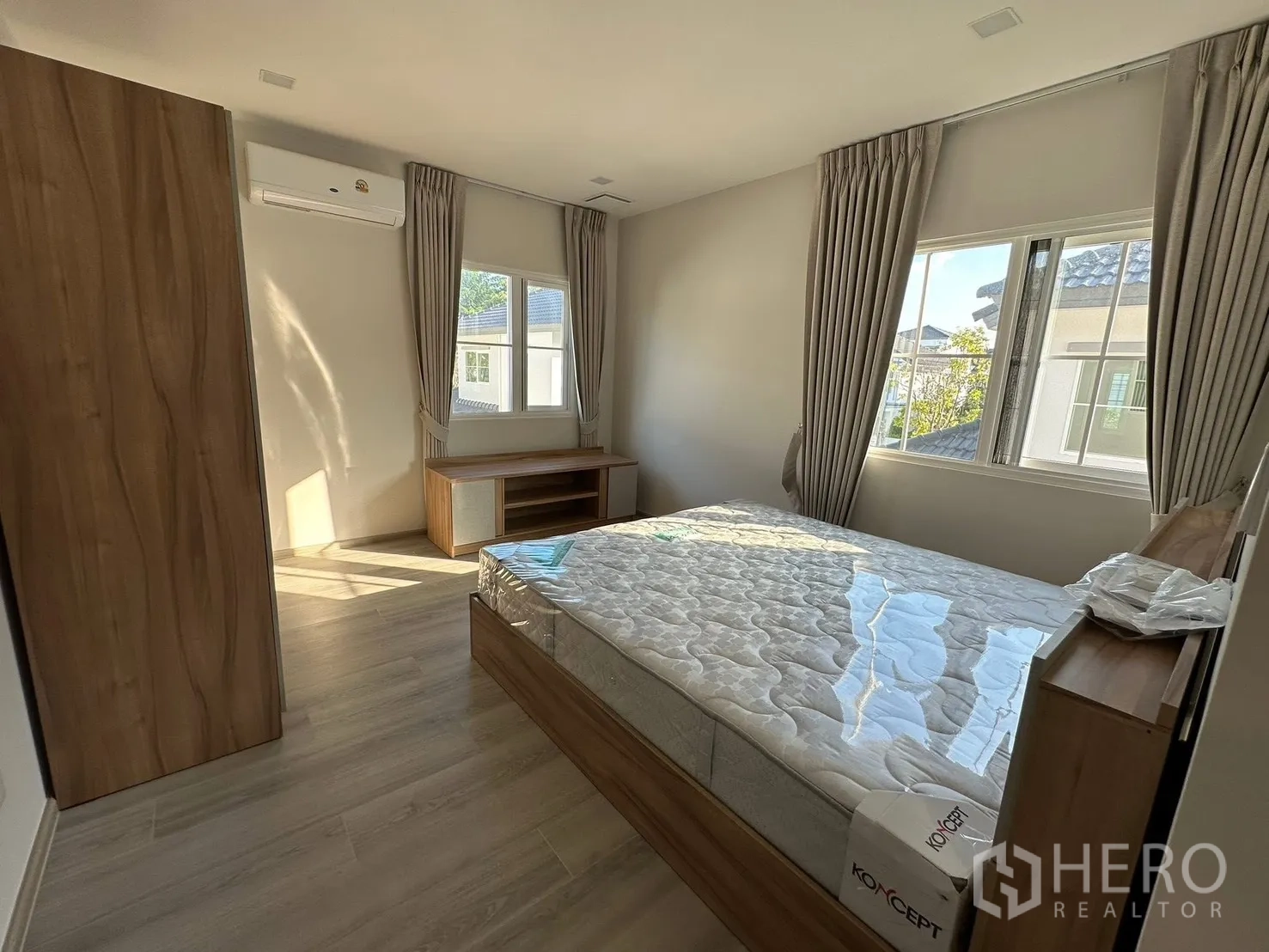 Detached House for rent in Bang Phli, Samut Prakan - Sunlit bedroom with bed near corner windows and curtains.