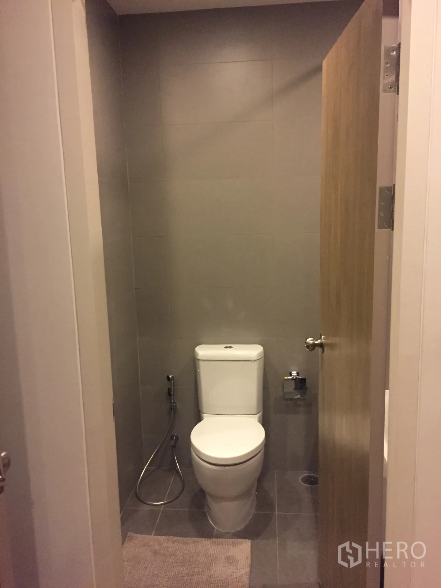 คอนโด ให้เช่าในPhaya Thai, Bangkok - ห้องน้ำโทนเทาพร้อมชักโครก สายฉีดชำระ และประตูไม้