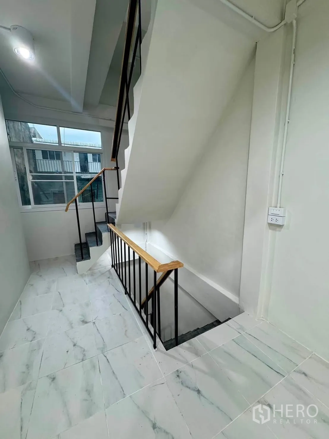 Shophouse for rent in Sathon, Bangkok - Shop space with staircase and wide roller shutter to the street.
