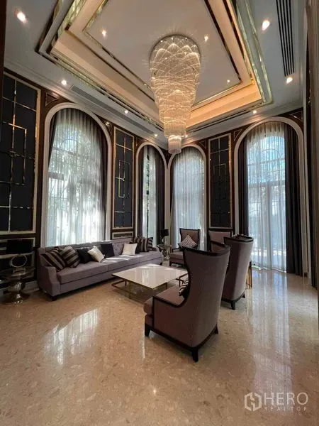 Detached House for rent or sale in Thawi Watthana, Bangkok - Formal sitting room with soaring ceiling, dark paneling and a statement chandelier.