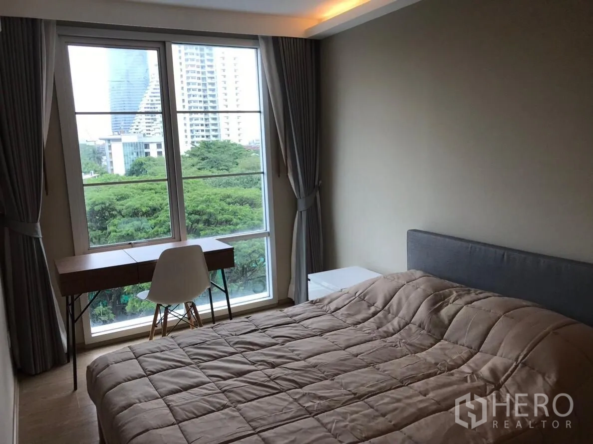 Condominium for rent in Watthana, Bangkok - Bright bedroom with large windows, green and city views plus a compact work desk.