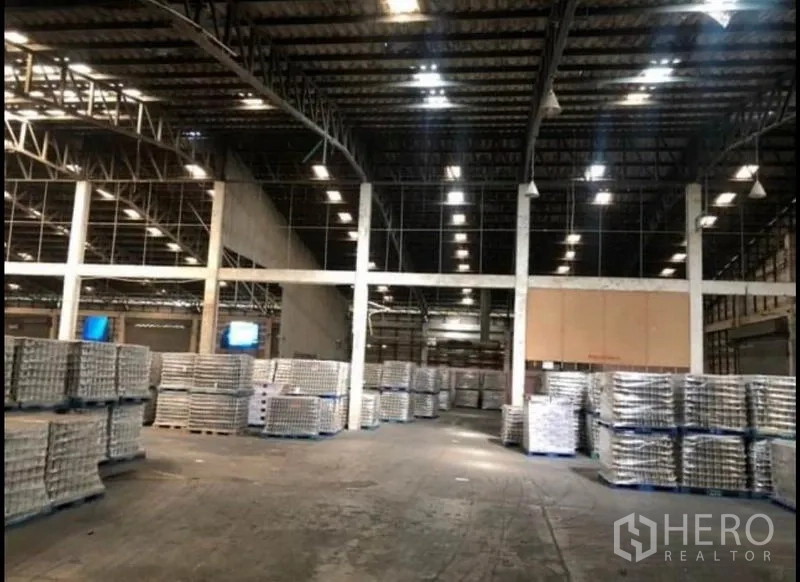 Factory for rent in Bang Khla, Chachoengsao - Large storage hall with bright lighting and multiple bays filled with pallets.