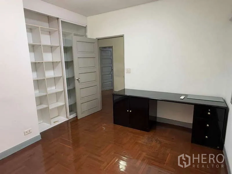 Detached House for rent in Bang Kapi, Bangkok - Study room with built‑in open shelves and a long black work desk.