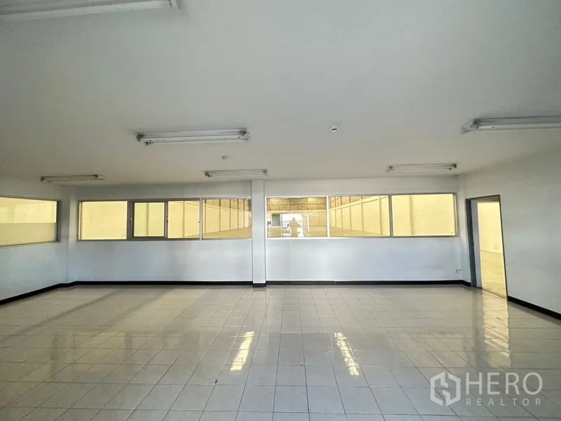 Factory for rent in Si Racha, Chon Buri - Spacious office area with glossy tiled floor, multiple windows and ceiling lights.