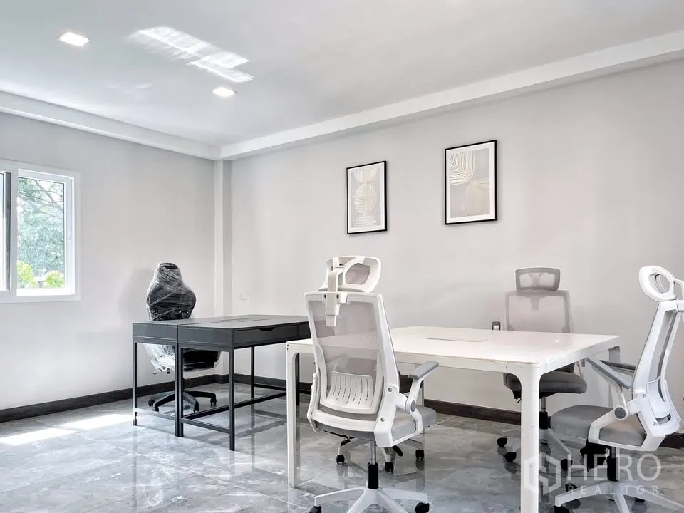 Home Office for rent in Watthana, Bangkok - Bright private office room with desks and ergonomic chairs next to a window.