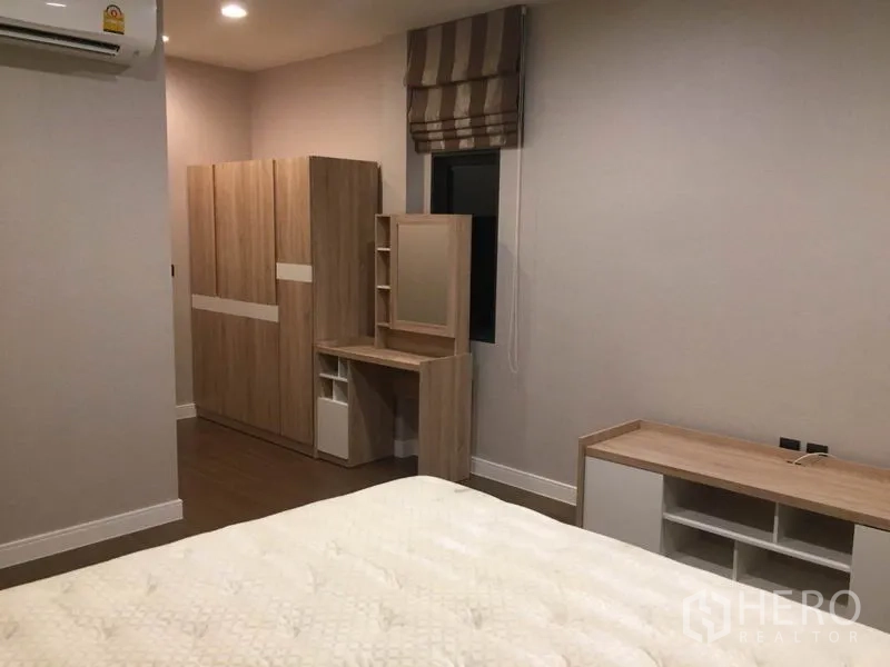 Detached House for rent in Bang Kapi, Bangkok - Bedroom with light-wood built-in wardrobe, vanity and TV console.