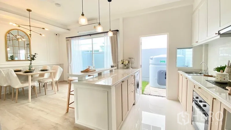 联排别墅 出租在Prawet, Bangkok - 开放式中岛厨房与餐区，朝向后院，通透明亮