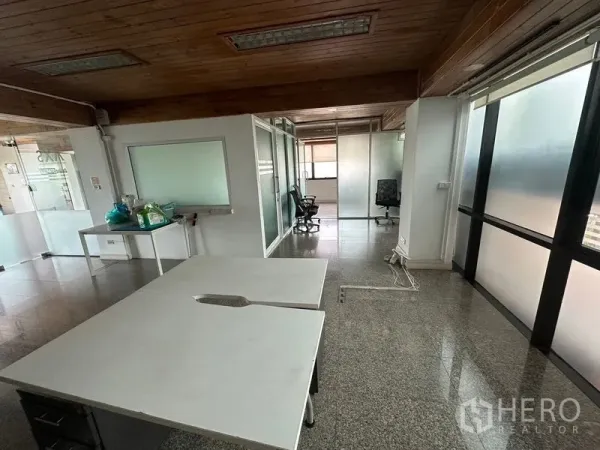 Office Space for rent - Spacious office area with glass partitions, worktables, natural light and granite-style floors.