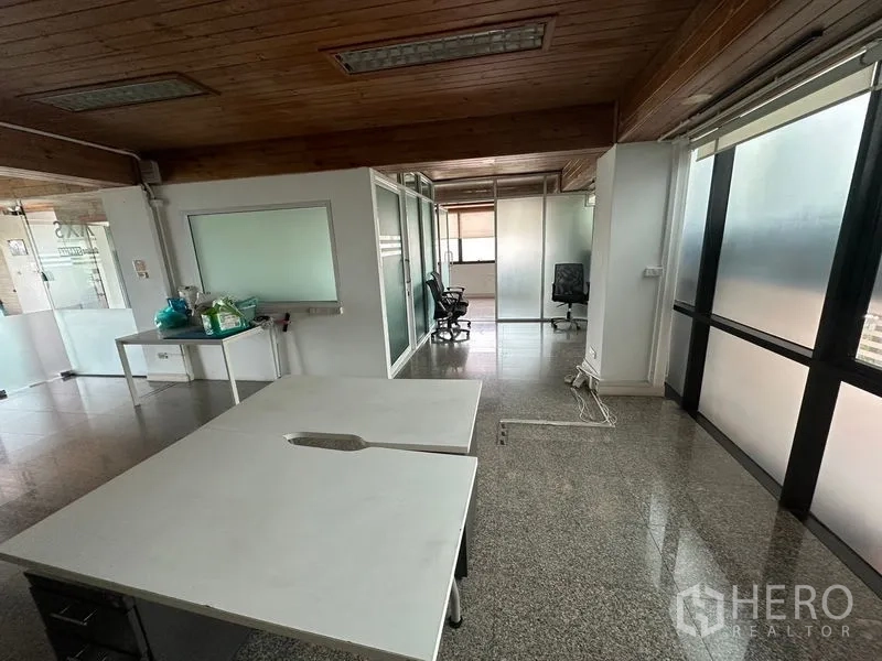 Office Space for rent - Spacious office area with glass partitions, worktables, natural light and granite-style floors.