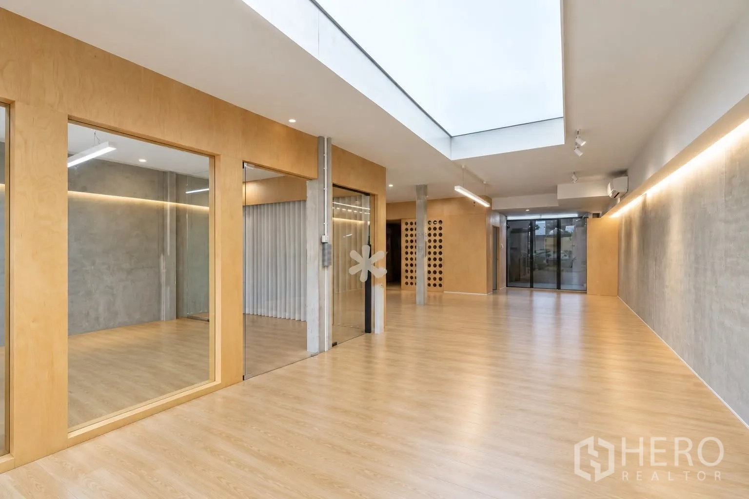 Retail Space for rent in Watthana, Bangkok - Bright open retail interior with wood flooring, skylight, glass partitions, and concrete accents.