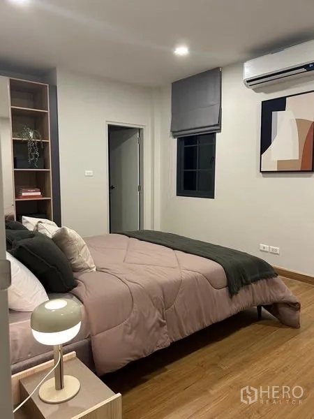 Detached House for rent or sale in Bang Phli, Samut Prakan - Guest bedroom with double bed, built‑in shelving and door to an ensuite bathroom.